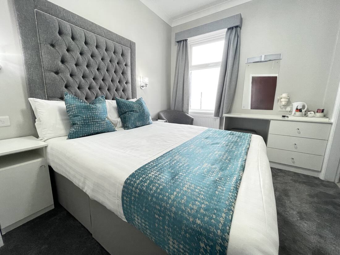Double room with buttoned headboard at the Doric Hotel