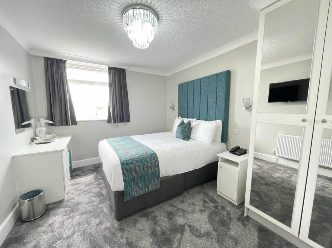 Cosy room with teal headboard at the Doric Hotel