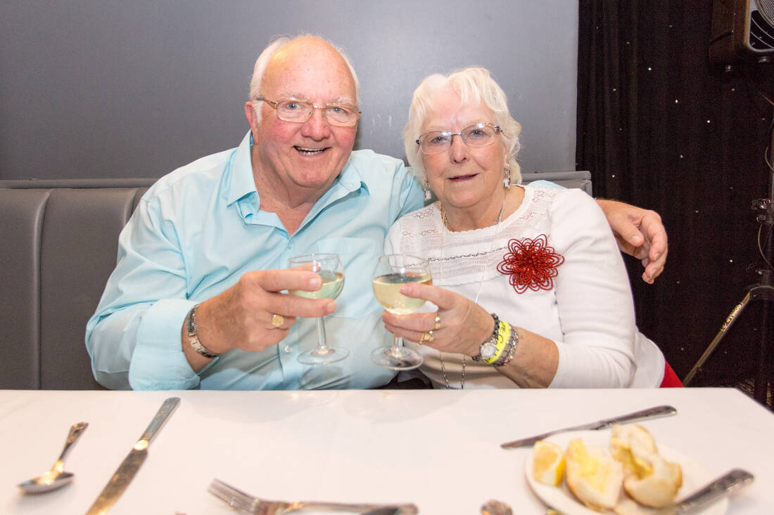 A couple raising a glass at dinner at the Doric Hotel